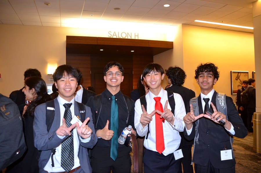 Four delegates outside Salon H, smiling between sessions