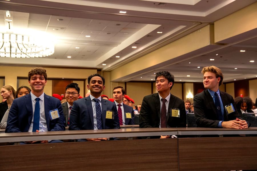 Four delegates smiling at the opening ceremony